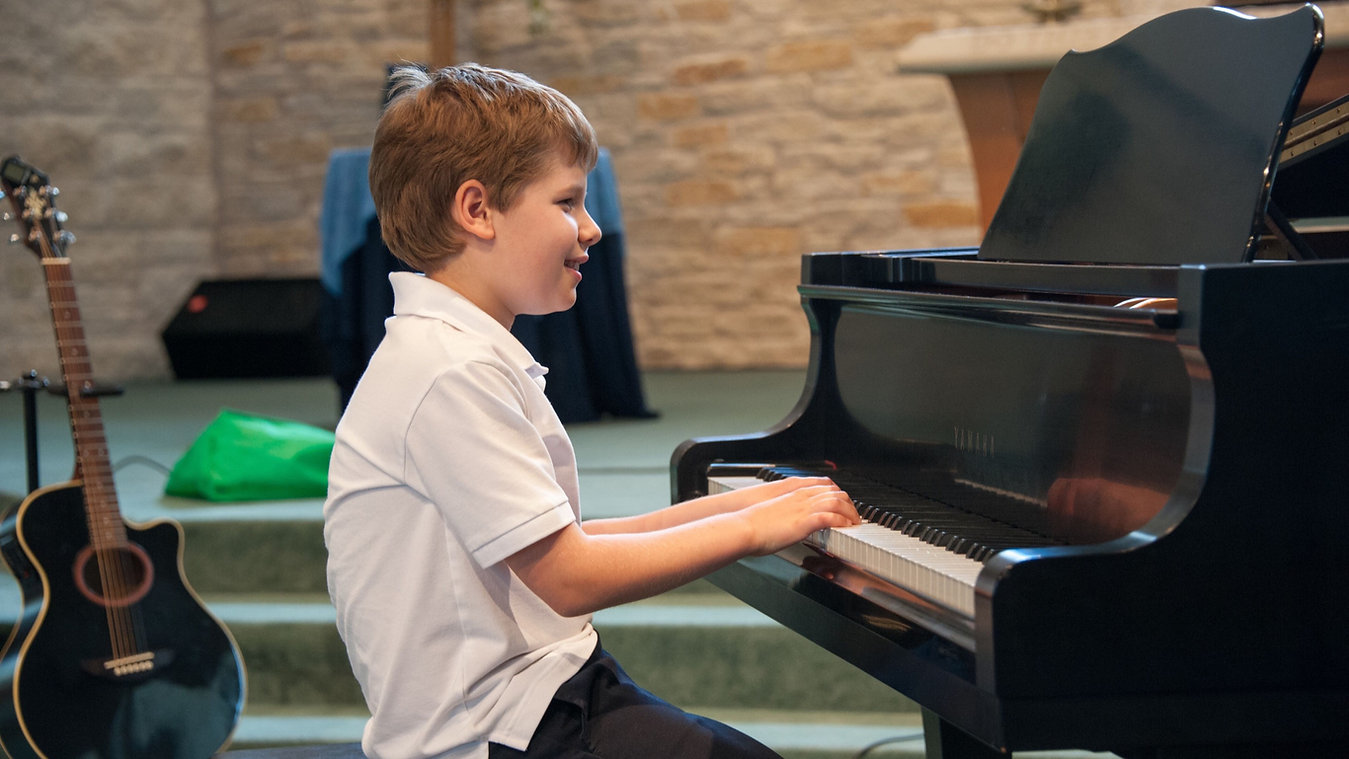 young boy taking piano lessons