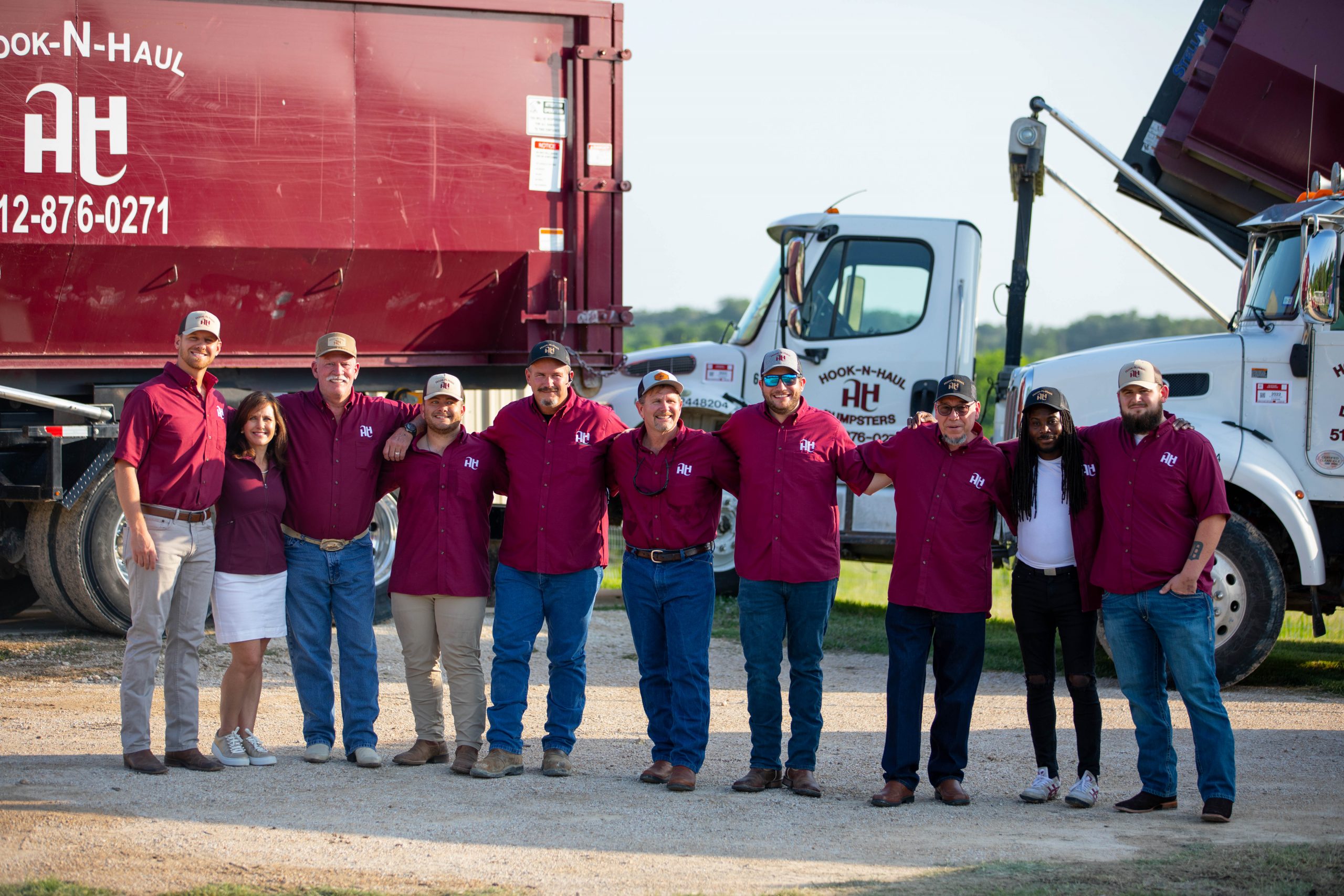 Hook-N-Haul Team standing in front of trucks