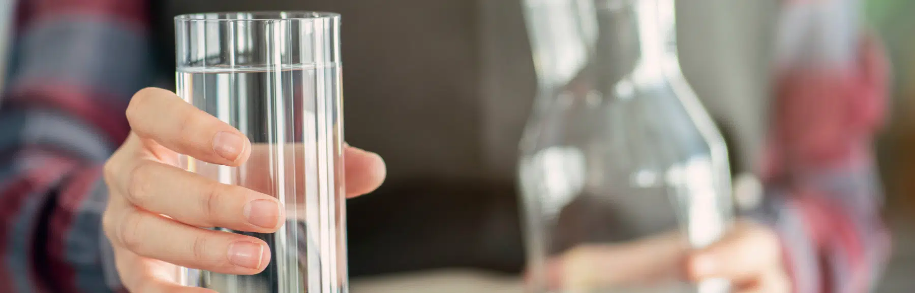 Woman holding out a glass of water