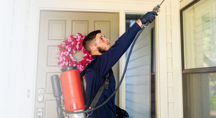 Pest Control working on the exterior of a home